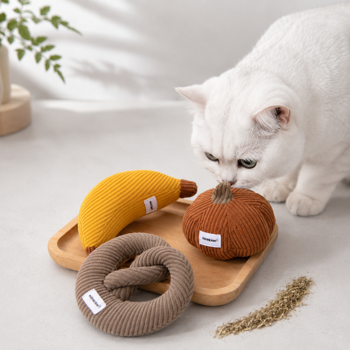 Cat smelling catnip toys on a wooden tray
