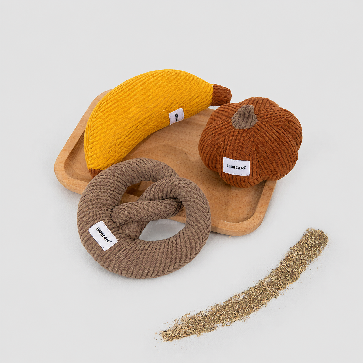 Three corduroy cat toys displayed beside loose catnip