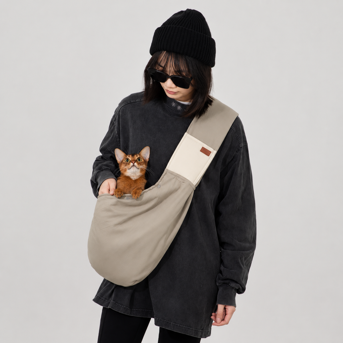 Cat resting inside a soft beige sling carrier