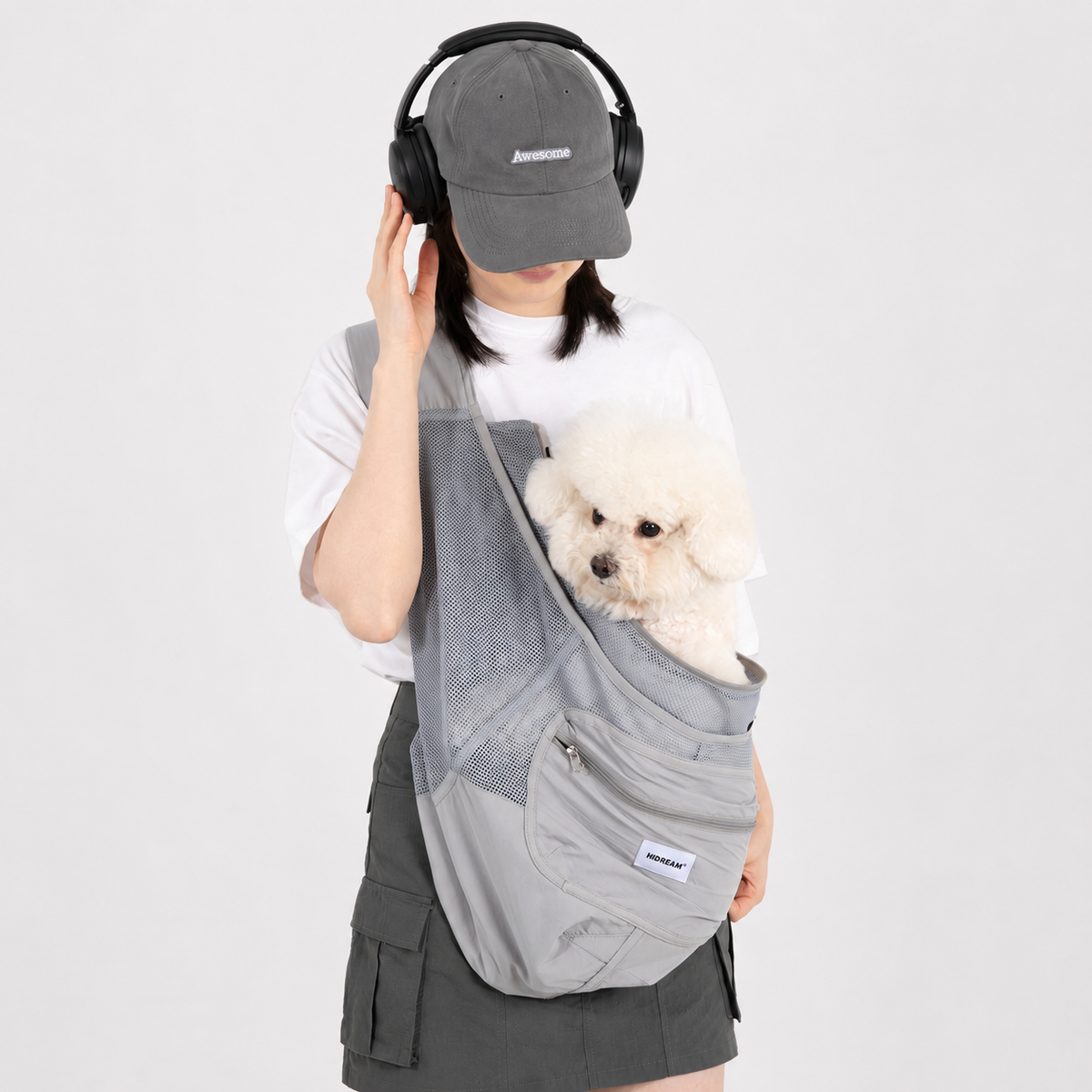 Small dog in a grey sling during a daily outing